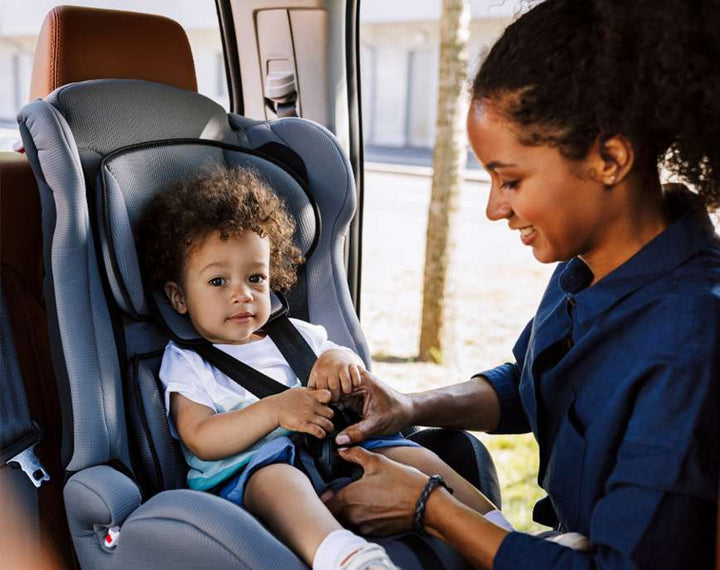 Mom putting baby in carseat