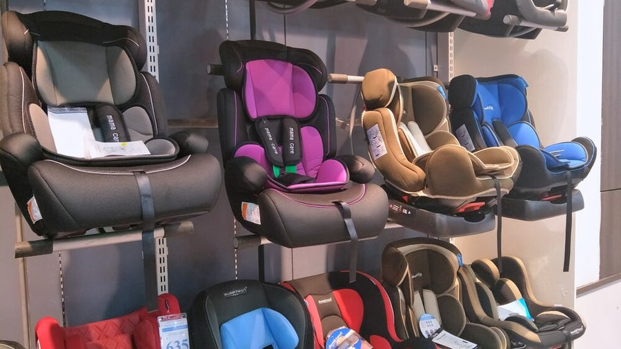 baby car seats displayed on a wall