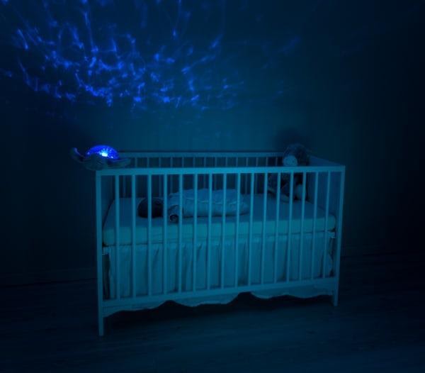 Baby sleeping in crib with blue light