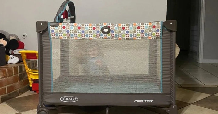 A baby in a Graco Pack 'n Play