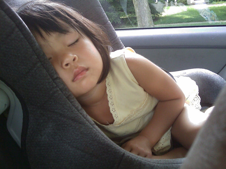 toddler sleeping in a car seat