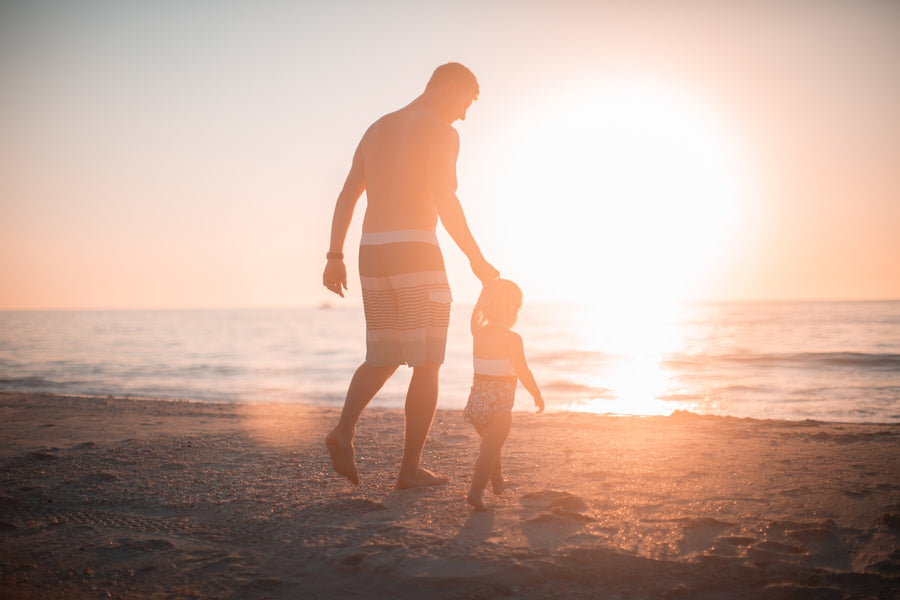 father walking with son on a beach