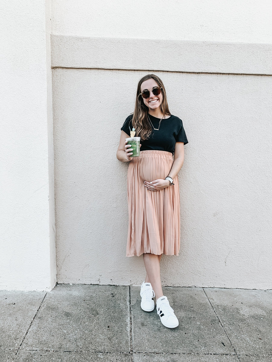 a pregnant woman holding a cup