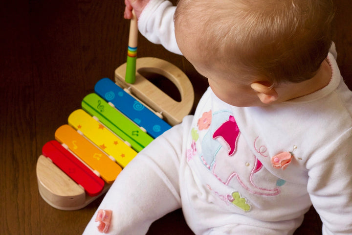 a baby playing with a musical toy