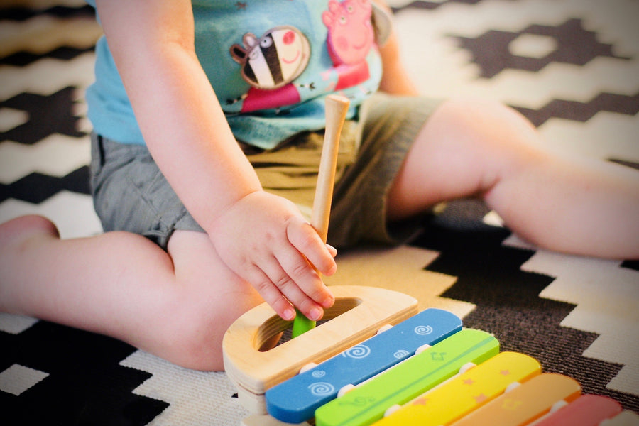 Baby with toy instrument