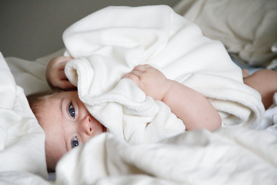  a baby grabbing at a blanket