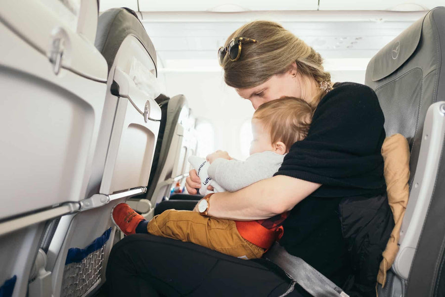 Mother holding baby in a plane