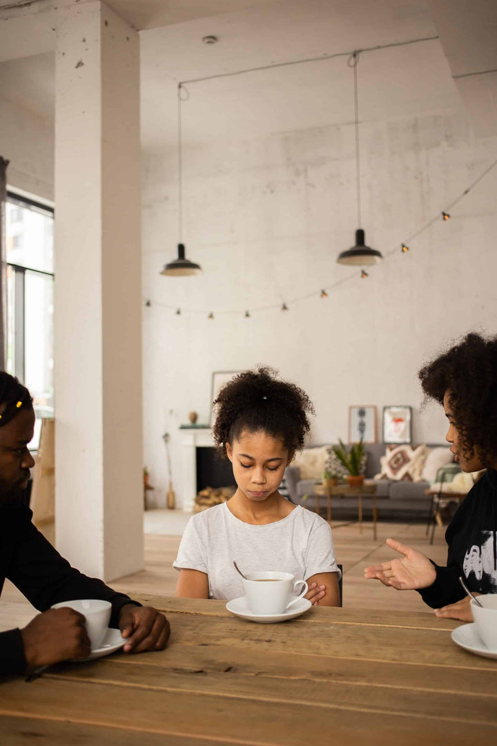 Mother speaking to daughter sitting at table