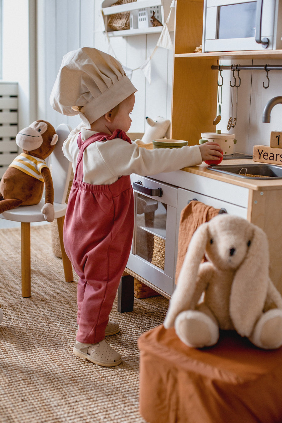 a baby using a play kitchen