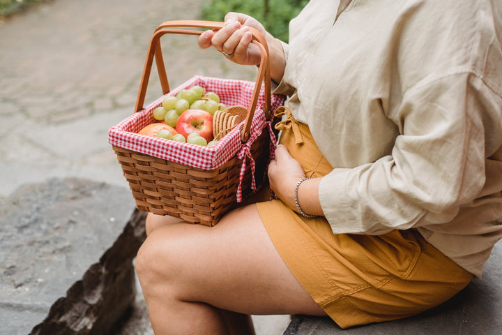 a pregnant woman holding a basket of fruit