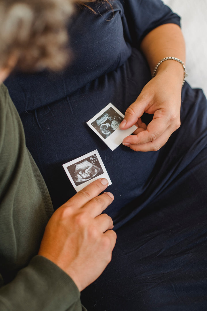 Couple holding ultrasound pictures