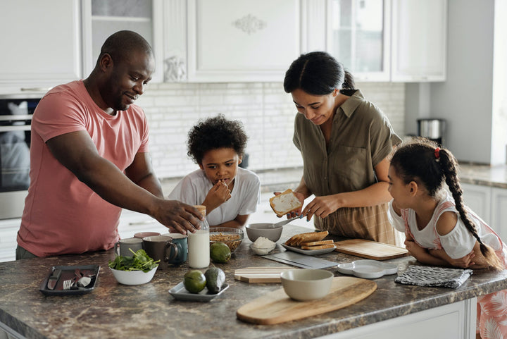A family cooks together around a kitchen island