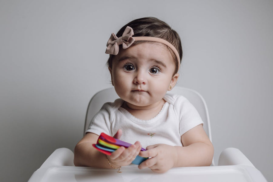 baby holding spoons