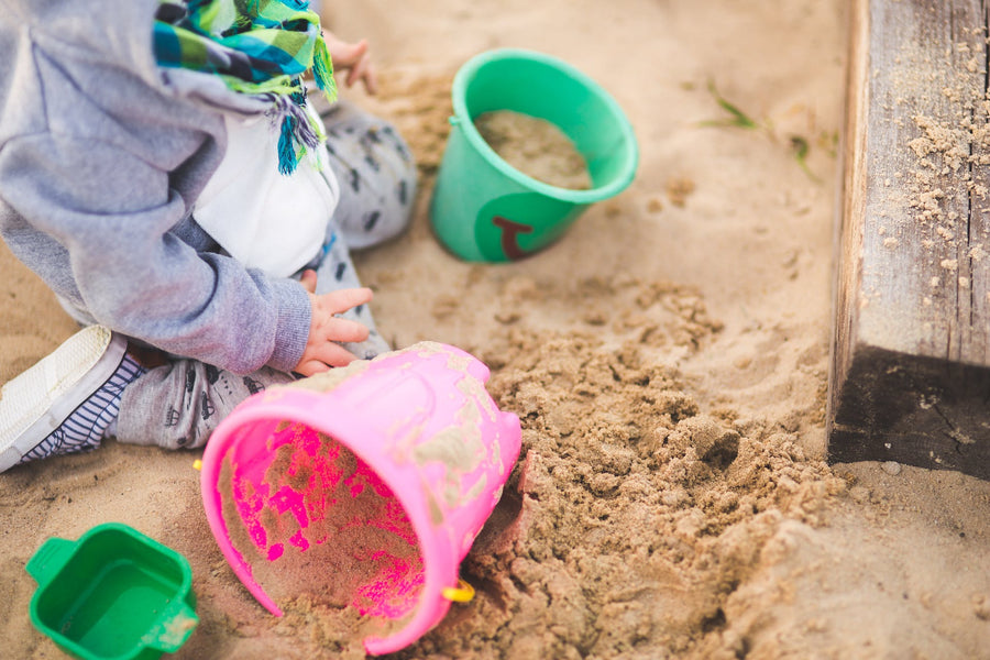 a baby playing in a sandbox