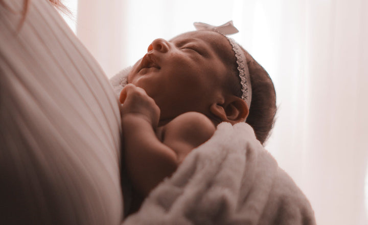 A mother holds her newborn baby in her arms