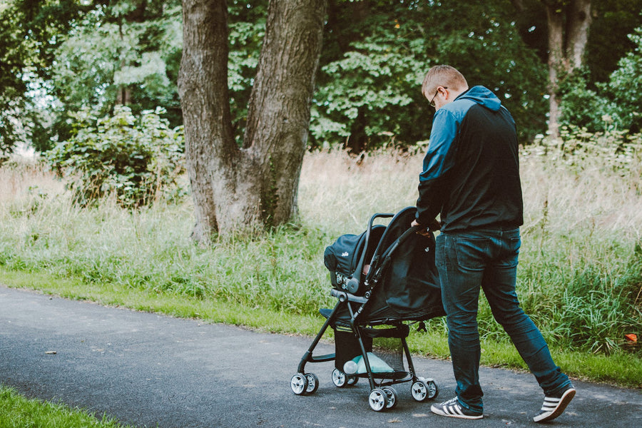 A father pushes a stroller in a park