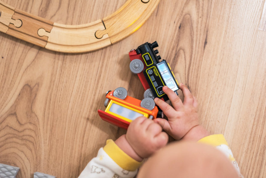 Baby hands play with wooden train set