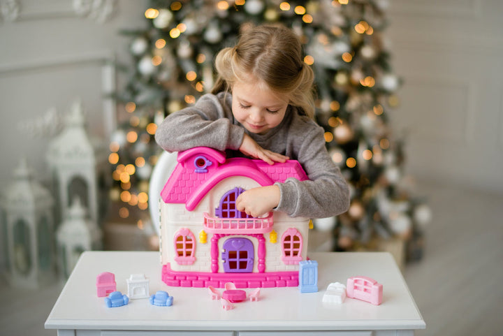  a girl playing with a doll house