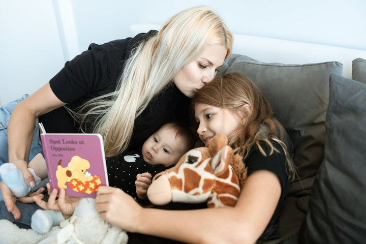 a mother reading an animal themed baby book to her children