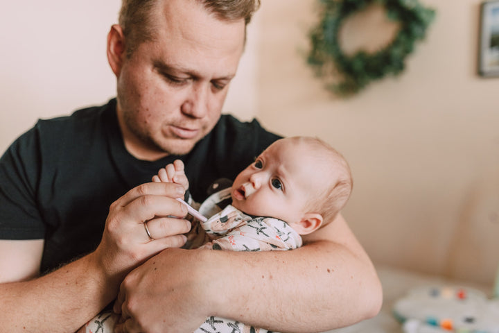 father using a baby thermometer on a baby