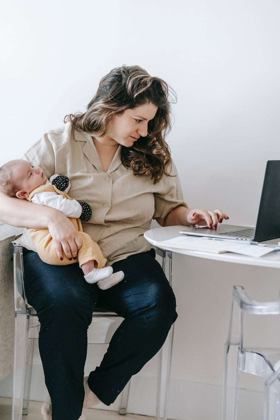 a mother holding her baby and looking online for a lactation consultant