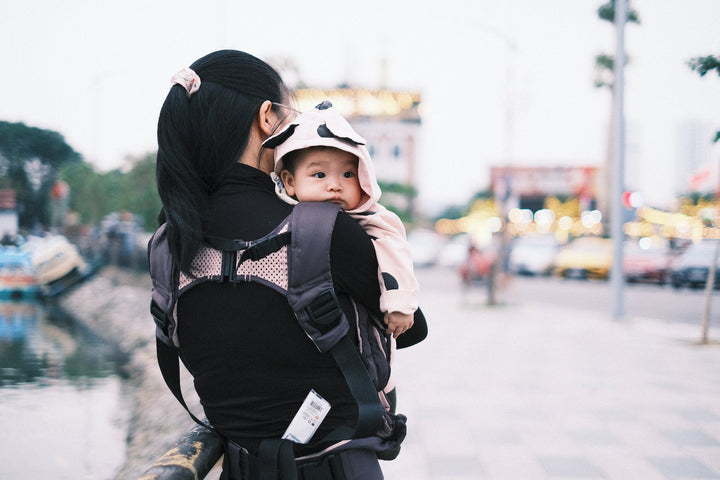  Woman carrying her baby on a street