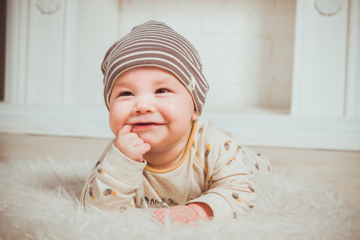 Baby smiling with finger in mouth