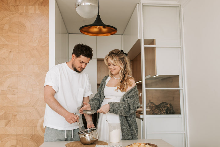 man and pregnant woman cooking together