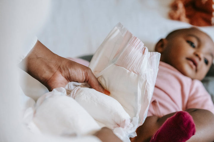 mom changing baby diaper