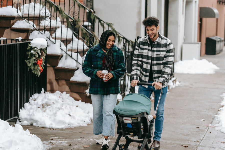 couple walking a baby in an umbrella stroller