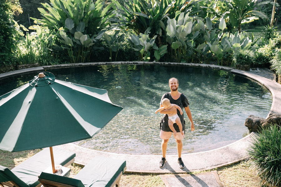father standing at a pool with his baby