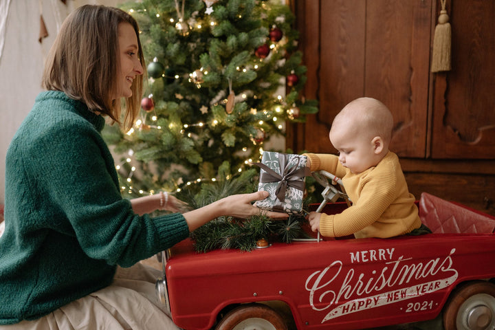  a mother giving a baby a holiday gift