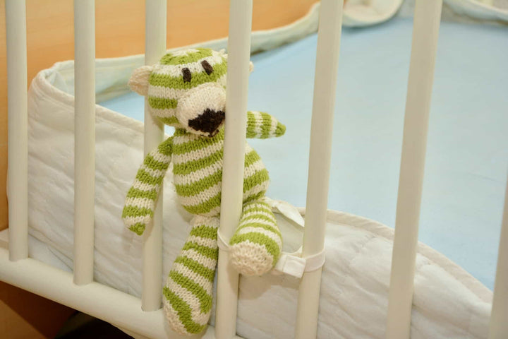 Crib with a stuffed teddy bear in it