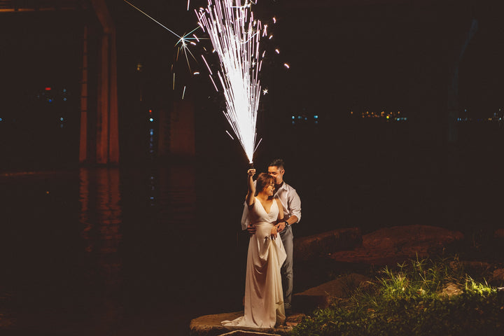 couple holding each other with a firework