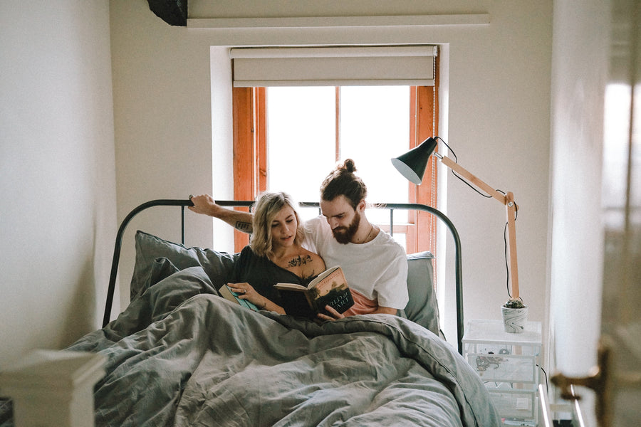 couple reading pregnancy books in bed