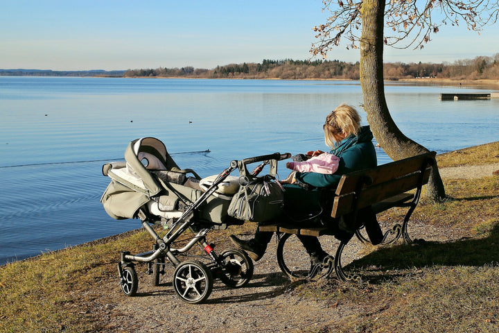 Women with baby and stroller in the park by the water